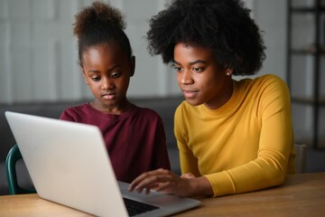 Woman and Young Girl Looking at Laptop Screen Together, Focused