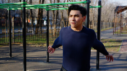 Young man doing outdoor fitness training at sports ground.