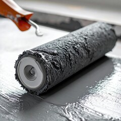 Gray paint roller on a painted surface