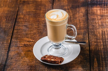 Classic caffe latte served in glass cup on wooden table