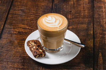 Caffe latte with leaf latte art served on wooden table
