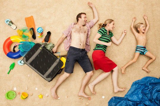 Family playfully posing with beach props in an artificial wave scene