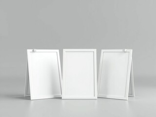 Three white picture frames on a table