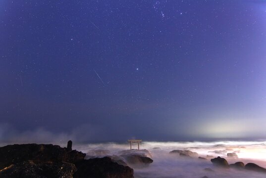 波に打たれる大洗磯間神社の鳥居と星空　シリウス・流れ星
