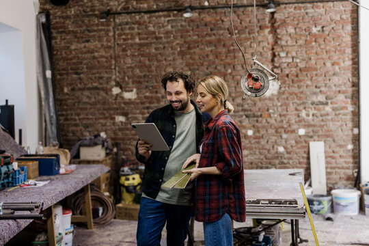Couple planning home renovation and energy consulting at construction site