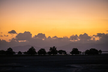 Golden Sunset Sky Over Silhouetted Trees and Mountains