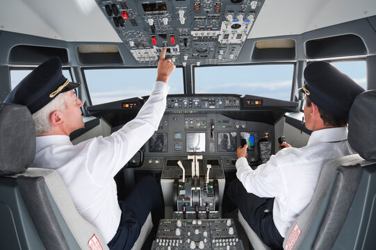 Pilot and co-pilot operating controls in airplane cockpit