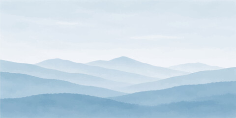 A misty mountain landscape at sunrise features a vast range of blue hills and snowy peaks under a glowing morning sky where fog and clouds drift over the forest valley © MDNUR