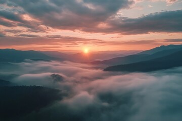 A breathtaking view of a sunrise over a mountain range, with the sun peeking through the clouds and casting a warm glow on the landscape.