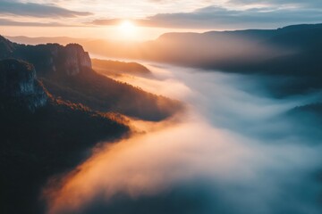 A breathtaking sunrise over a mountain range, with the sun peeking through the clouds and casting a warm glow on the landscape.