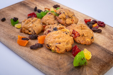 Cookies with freeze dried fruits and mint on wooden cutting board. Image selective focus photography