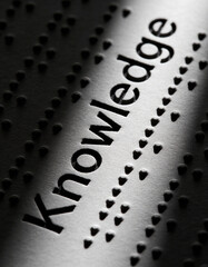 World Braille Day awareness image featuring a macro shot of raised braille dots forming the word &ldquo;Knowledge&rdquo;, dramatic high-contrast shadows, dark minimal background, powerful visual storytelling, 