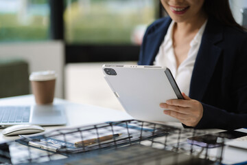 Obraz premium business woman sitting at her desk, reading stats and graphs on paperwork at the office.