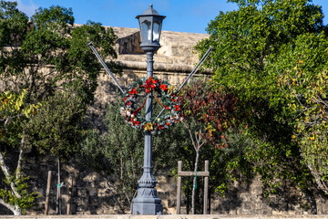 A Christmas wreath on a lamppost in a square in Valletta, Malta.