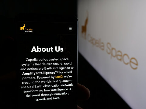 Stuttgart, Germany - 12-17-2025: Person holding smartphone with web page of US satellite company Capella Space on screen in front of logo. Focus on center of phone display.