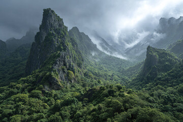 Fog covered jungle mountains with dramatic limestone formations under cloudy sky creating mysterious and moody atmosphere in lush green forest landscape