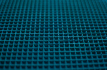 This is a close-up of a waffle-like texture in vibrant sky blue color, featuring a uniform grid of raised square cells with subtle shadows and a soft, tactile surface.