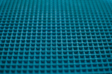 This is a close-up of a waffle-like texture in vibrant sky blue color, featuring a uniform grid of raised square cells with subtle shadows and a soft, tactile surface.