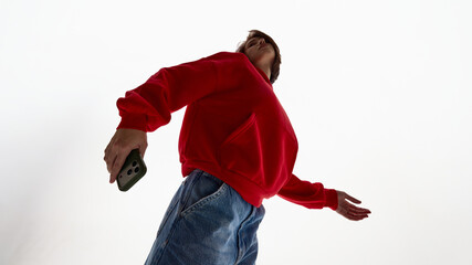 Woman posing dynamically with smartphone in hand. Concept of mobile lifestyle advertising, smartphone brand promotion, digital product campaign, and visual storytelling for tech brands