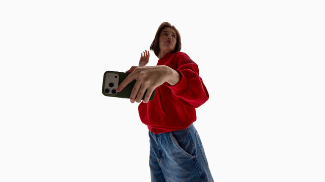Woman reaching upward while holding smartphone. Concept of smartphone usage in ads, mobile communication promotion, tech brand marketing content, and digital campaign visuals.