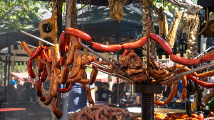 Grilled sausages and meats hanging on display.
