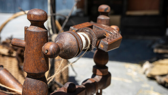 Close-up of a wooden spinning wheel component.