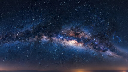 A person of East Asian descent with fair skin wearing a protective suit standing on a mountain looking at the Milky Way galaxy on a clear night with stars and a bright core shining.