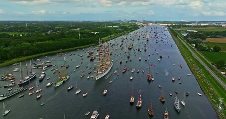 Aerial view of Sail Amsterdam 2025, Sailing Parade in Amsterdam in August 2025. Many ships and boats of different sizes participate in the festival, sailing along the main canal leading to Amsterdam