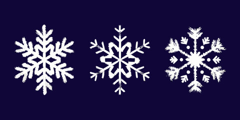 Chalkboard art featuring three distinct white snowflake designs on a dark background