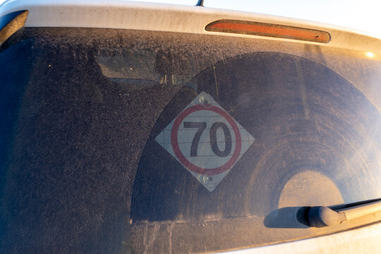 Dirty car rear window with speed limit sign