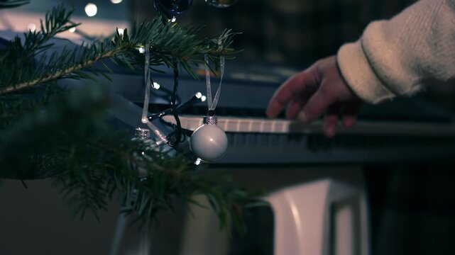 Christmas tree baubles with woman playing Christmas carols on piano organ 