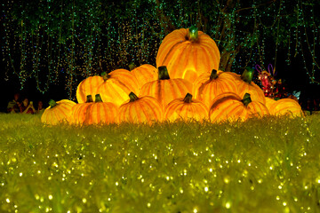 Christmas-themed pumpkin lanterns are placed on the lawn as part of the outdoor decorative lighting
