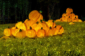 Christmas-themed pumpkin lanterns are placed on the lawn as part of the outdoor decorative lighting