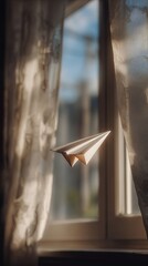 A paper airplane floats gently near a window, illuminated by soft natural light, creating a serene and whimsical atmosphere.