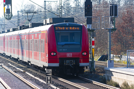 Red S-Bahn train number 7 direction leaving railway station of Zeppelinheim near the Frankfurt Airport on a sunny autumn day. Photo taken November 22nd, 2025, Zeppelinheim, Neu-Isenburg, Germany.