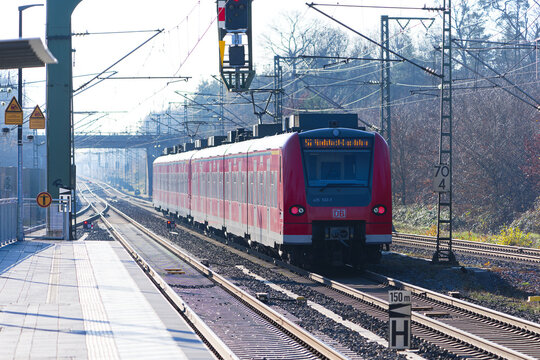 Red S-Bahn train number 7 direction leaving railway station of Zeppelinheim near the Frankfurt Airport on a sunny autumn day. Photo taken November 22nd, 2025, Zeppelinheim, Neu-Isenburg, Germany.