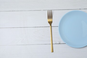 Empty plate and cutlery on colored background, top view
