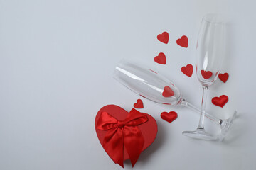 Festive background with a bottle of champagne, two glasses and hearts and gift boxes. A romantic...