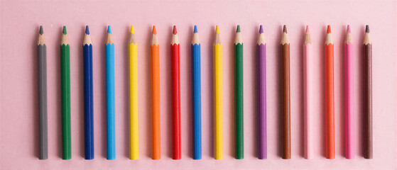 Colorful pencils row on pink background