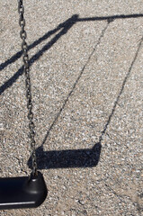 swing seat and shadow on gravel