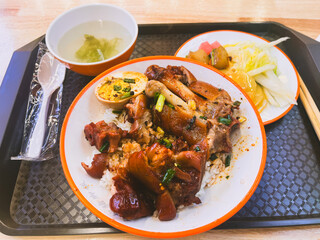 Fototapeta premium Traditional Chinese Pig's Foot Rice Zhu Jiao Fan served on a rustic street-side table in Chongqing China