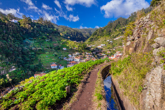 The famous levada's walking trail along the irrigation channel of levada above the typical madeiran village Marocos. Madeira, Portugal