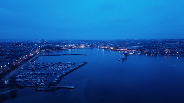 Aerial view of the city lights reflecting on the tranquil Geneva lake, creating a mesmerizing scene of urban beauty, Rade of Geneva, Geneva, Switzerland.