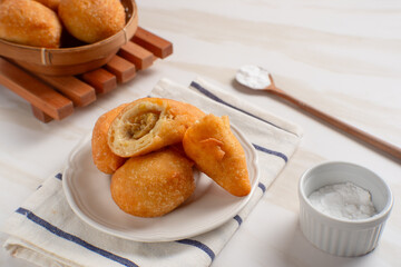 Indonesian fried bread, also known as "Roti Kue Bantal" (pillow bread), is often filled with banana, chocolate, or mung beans. Perfect for recipes, articles or any cooking content.