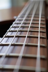 Fototapeta premium A close-up view of a guitar neck showcasing its strings, frets, and smooth wooden finish, highlighting craftsmanship and musical artistry.