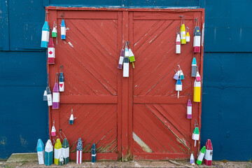 Decorated lobster fishing buoys hanging on an old fishing hut.