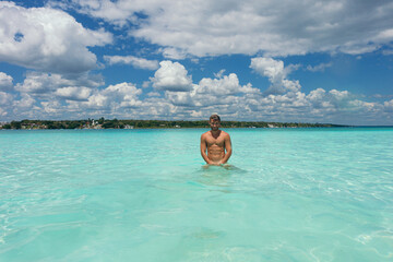 Man enjoying clear turquoise water in tropical paradise in bacalar,mexico abs