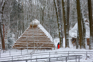 Conical straw huts in in a snowy winter forest. Shevchenko Grove, Lviv, Ukraine