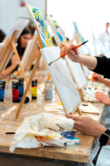 Women painting on canvas creating art in workshop