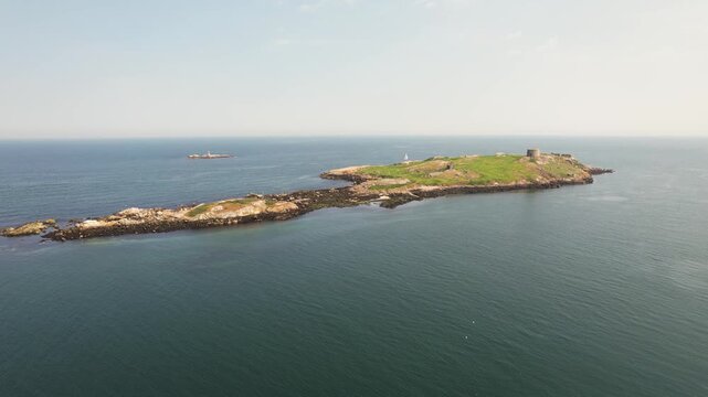 Aerial view of Dalkey Island, its historic Martello tower, and a small lighthouse surrounded by the deep blue sea, Dalkey Island, County Dublin, Ireland.